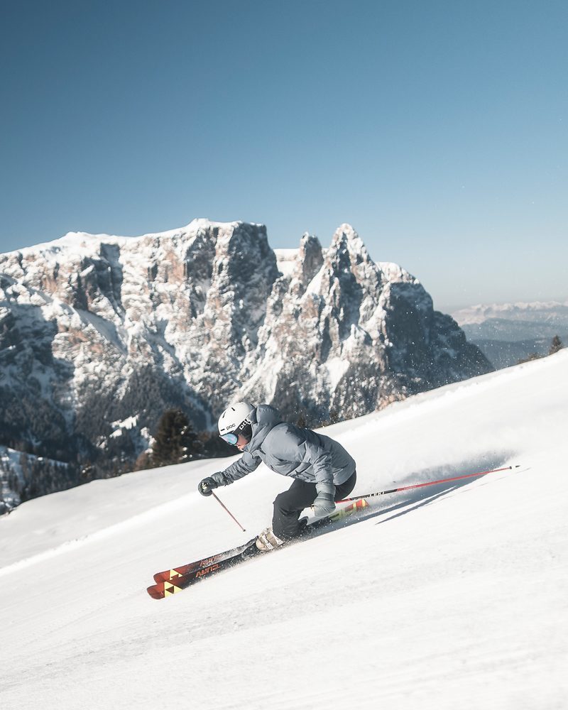 An athletic skier on the slopes against the striking backdrop of the Schlern in South Tyrol.